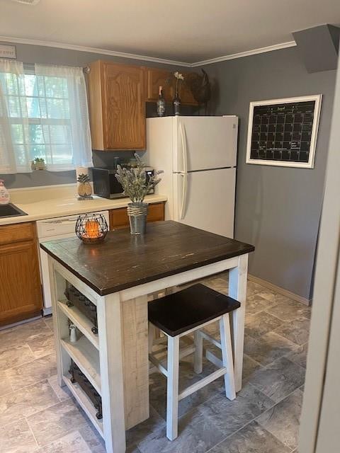 kitchen featuring crown molding, a breakfast bar area, white fridge, and dishwasher