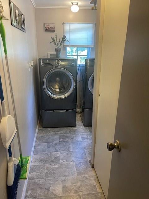 clothes washing area with washing machine and clothes dryer and ornamental molding