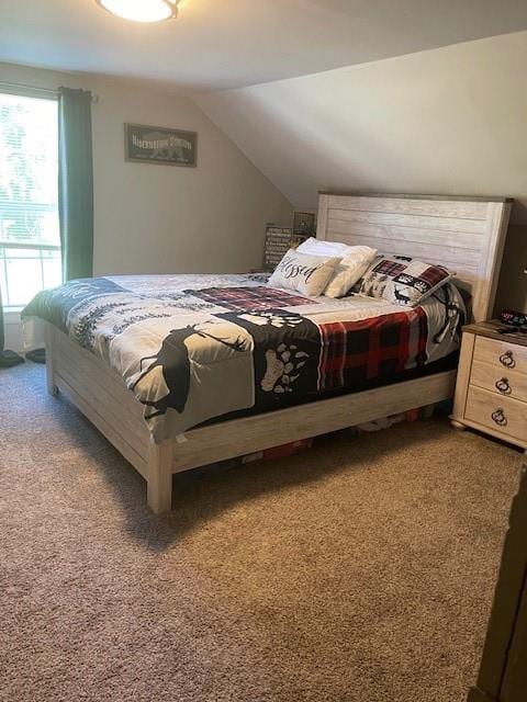 carpeted bedroom with lofted ceiling