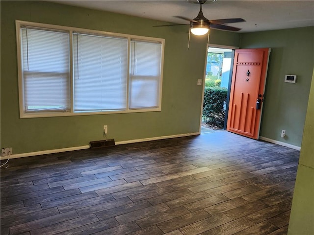 empty room featuring dark wood-type flooring and ceiling fan