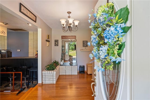 entryway with hardwood / wood-style flooring and an inviting chandelier