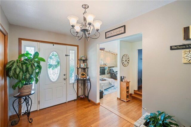 foyer entrance with a notable chandelier and light hardwood / wood-style floors