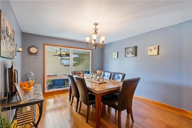 dining space featuring light wood-type flooring and a chandelier