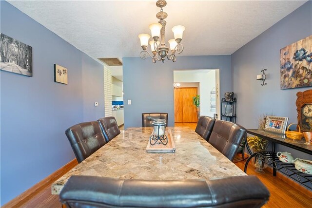 dining area with a notable chandelier and wood-type flooring