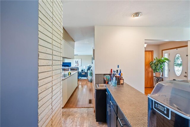 kitchen with blue cabinetry and light hardwood / wood-style floors