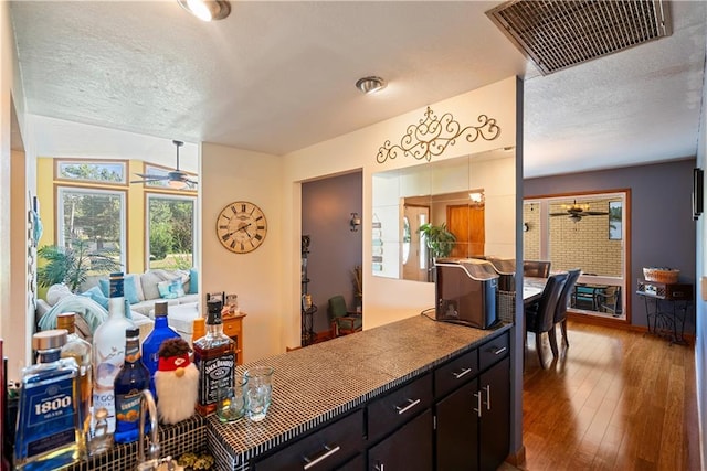 kitchen with dark hardwood / wood-style flooring, ceiling fan, and a textured ceiling