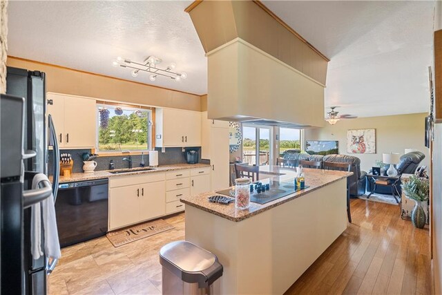 kitchen featuring black appliances, backsplash, sink, ceiling fan, and light wood-type flooring