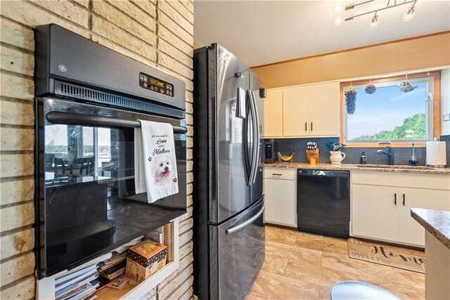 kitchen with black appliances, light stone counters, and white cabinets