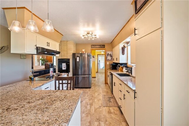 kitchen featuring black appliances, hanging light fixtures, sink, ventilation hood, and track lighting