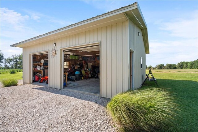 garage featuring a lawn and wooden walls