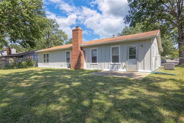 back of property featuring central AC and a lawn