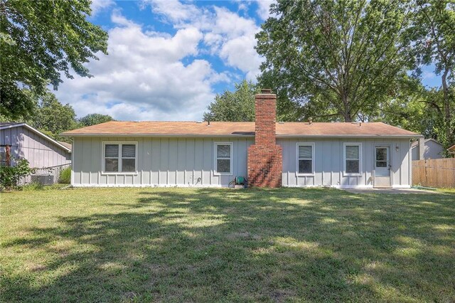 rear view of property featuring a lawn