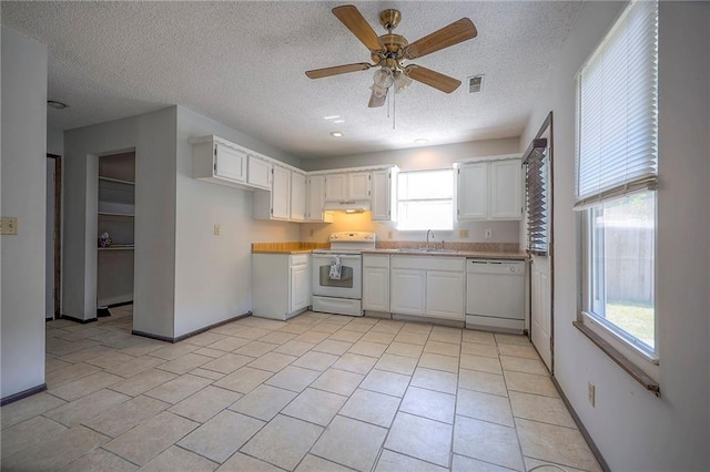 kitchen with plenty of natural light, ceiling fan, white appliances, and white cabinets