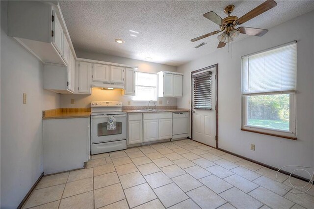 kitchen featuring white appliances, sink, ceiling fan, white cabinets, and light tile patterned flooring