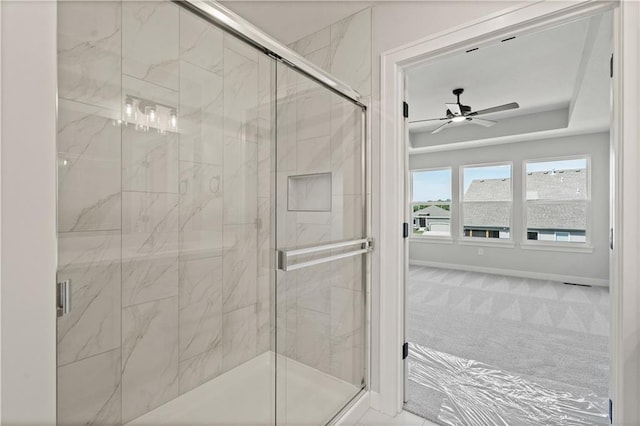 full bathroom with a marble finish shower, baseboards, and a ceiling fan