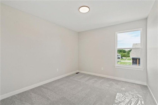 spare room with light colored carpet and baseboards