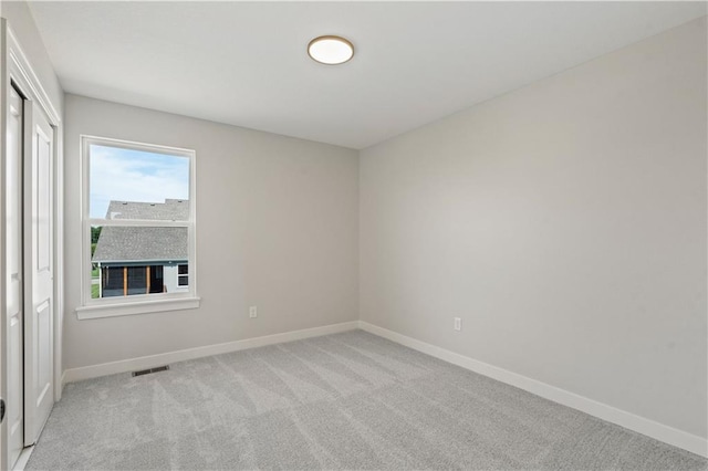 empty room with baseboards, carpet floors, and visible vents