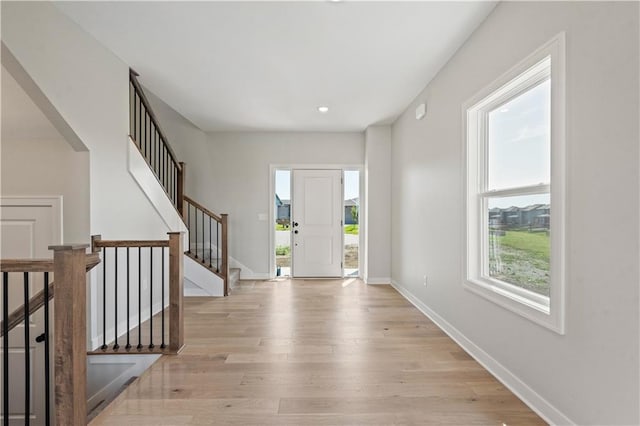 entryway featuring stairway, light wood-style floors, and baseboards