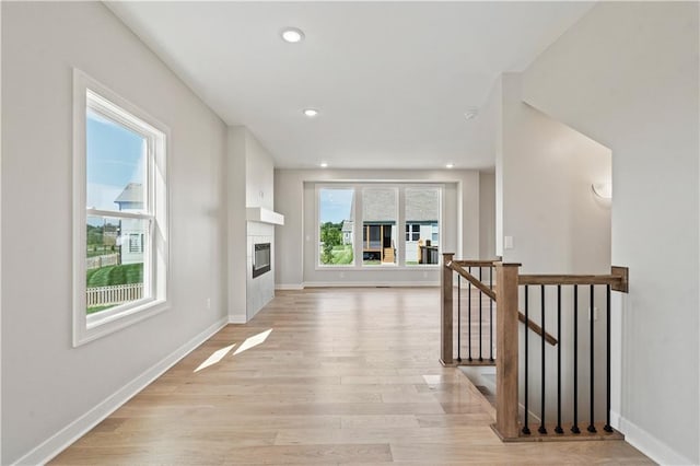 hall with recessed lighting, an upstairs landing, baseboards, and light wood finished floors