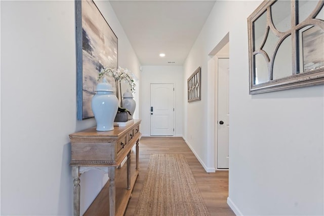 hallway with light hardwood / wood-style flooring