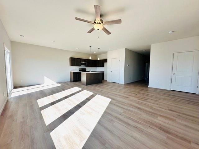 unfurnished living room with light wood-type flooring and ceiling fan