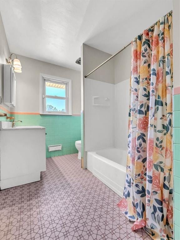 full bathroom with vanity, toilet, tile walls, and shower / bathtub combination with curtain