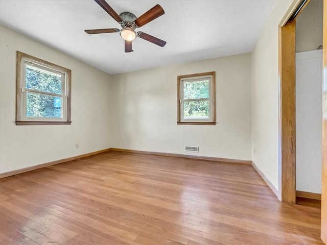 unfurnished bedroom with ceiling fan, multiple windows, and light hardwood / wood-style floors