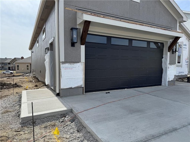 view of home's exterior featuring a garage, concrete driveway, and stucco siding