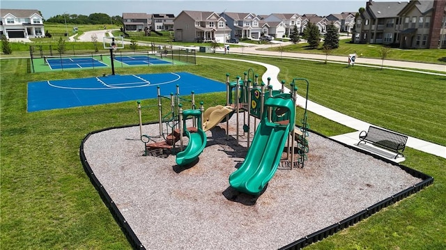 community jungle gym with a lawn, fence, and a residential view