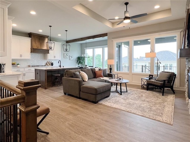 1511 SW Arbor Park Dr, Lees Summit, MO 64082 - living area with light wood-style floors, ceiling fan, a tray ceiling, and recessed lighting