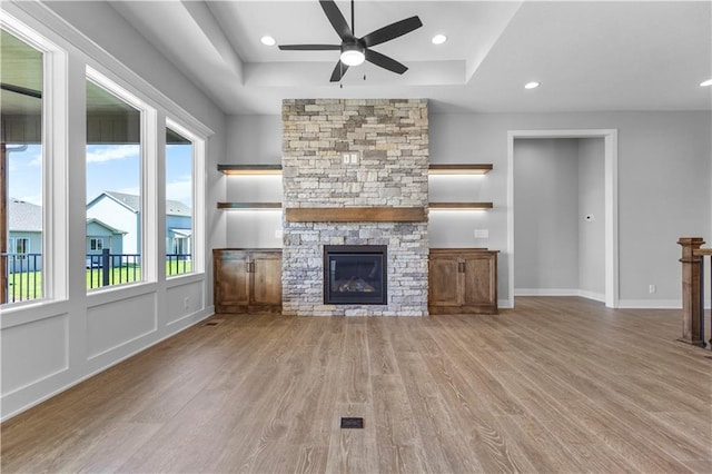 1511 SW Arbor Park Dr, Lees Summit, MO 64082 - unfurnished living room featuring ceiling fan, a fireplace, wood finished floors, a raised ceiling, and recessed lighting