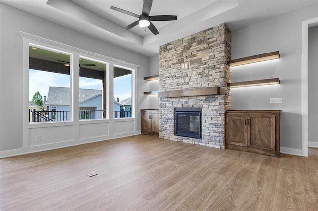1511 SW Arbor Park Dr, Lees Summit, MO 64082 - unfurnished living room with a raised ceiling, wood finished floors, ceiling fan, and a fireplace