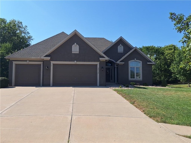 view of front of home with a garage and a front lawn