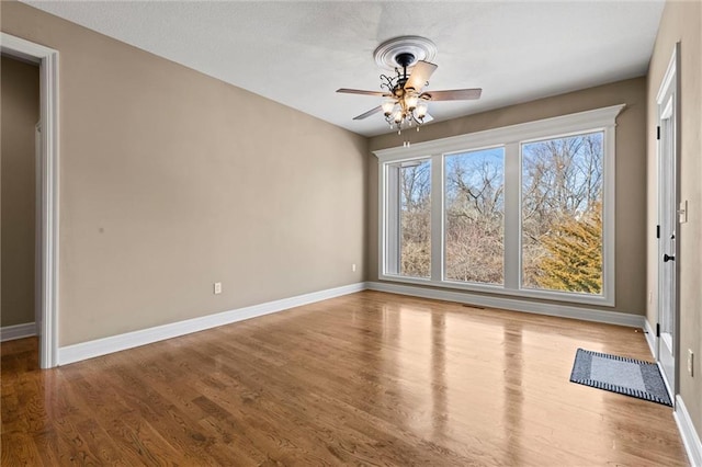 empty room with ceiling fan and light hardwood / wood-style floors