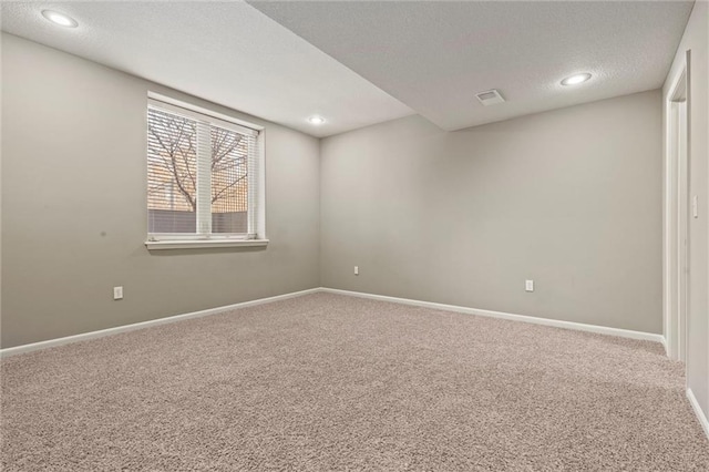 carpeted empty room with a textured ceiling