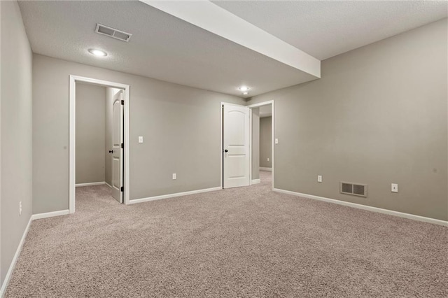 carpeted empty room with a textured ceiling