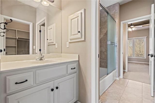 bathroom featuring tile patterned flooring, vanity, combined bath / shower with glass door, and ceiling fan