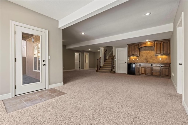 unfurnished living room with sink and light carpet