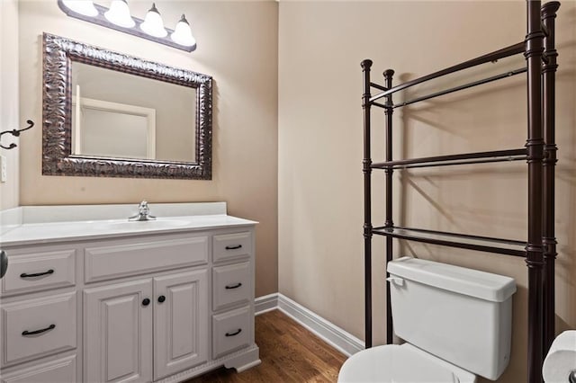 bathroom featuring vanity, hardwood / wood-style flooring, and toilet