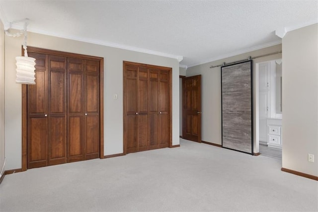 unfurnished bedroom with light carpet, connected bathroom, two closets, and ornamental molding