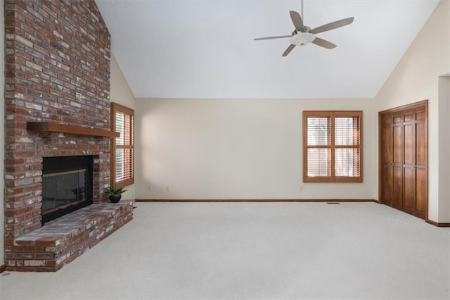 unfurnished living room with a brick fireplace, high vaulted ceiling, ceiling fan, and carpet flooring