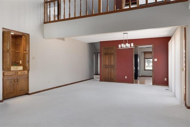 interior space featuring a towering ceiling and light colored carpet