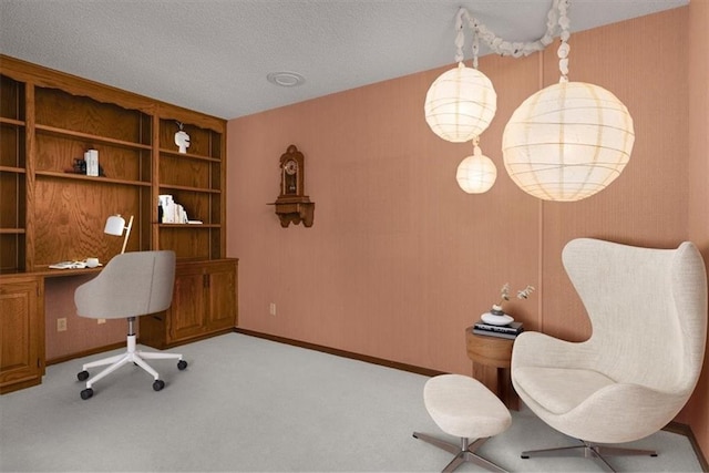 office area with built in desk, light carpet, and a textured ceiling