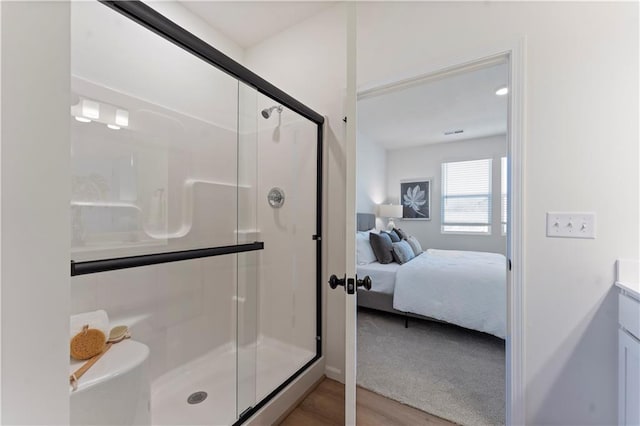 bathroom with wood-type flooring, vanity, and walk in shower