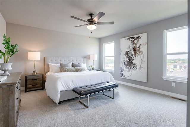 bedroom with light carpet, baseboards, visible vents, and a ceiling fan