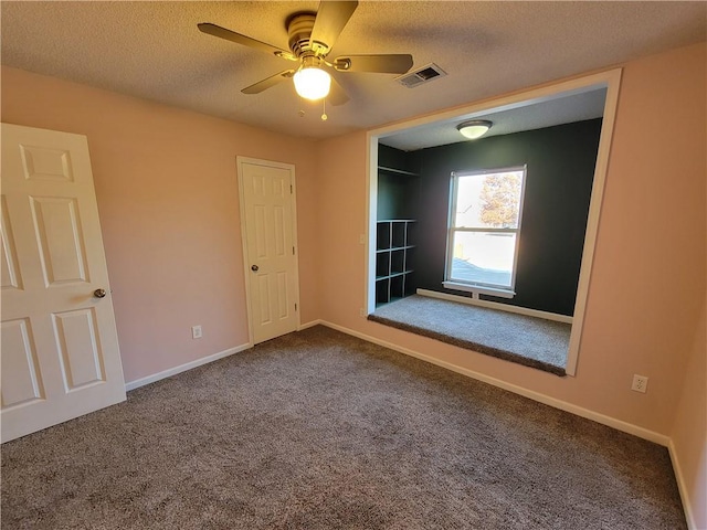 spare room featuring ceiling fan, carpet, and a textured ceiling