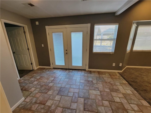 doorway to outside featuring beamed ceiling and french doors