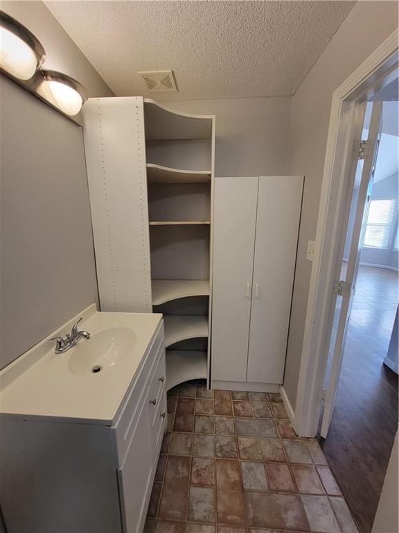 bathroom featuring hardwood / wood-style floors, a textured ceiling, and sink