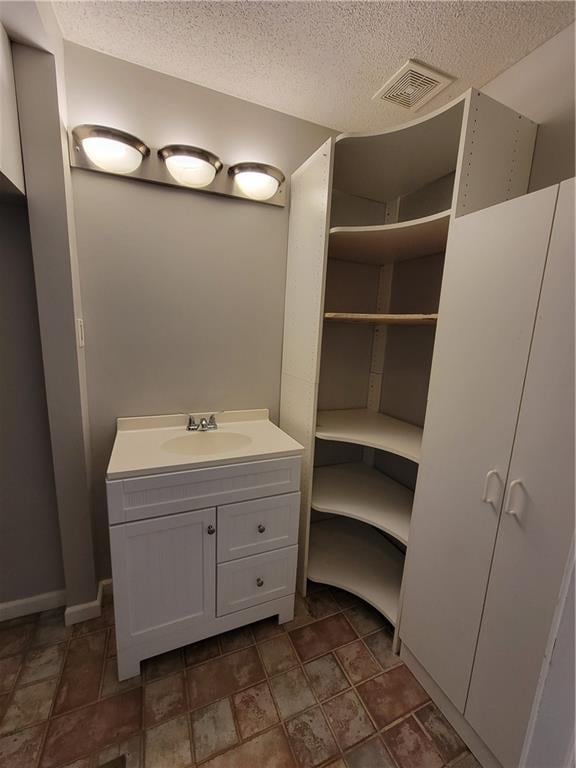 bathroom with vanity and a textured ceiling