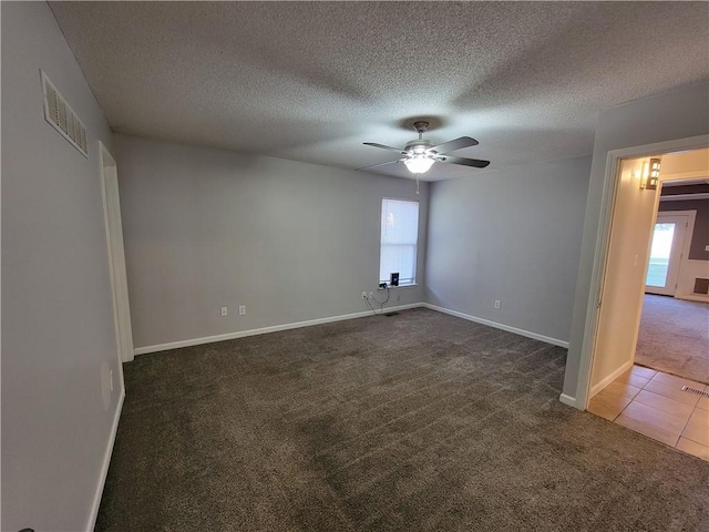 unfurnished room featuring dark colored carpet, plenty of natural light, and a textured ceiling